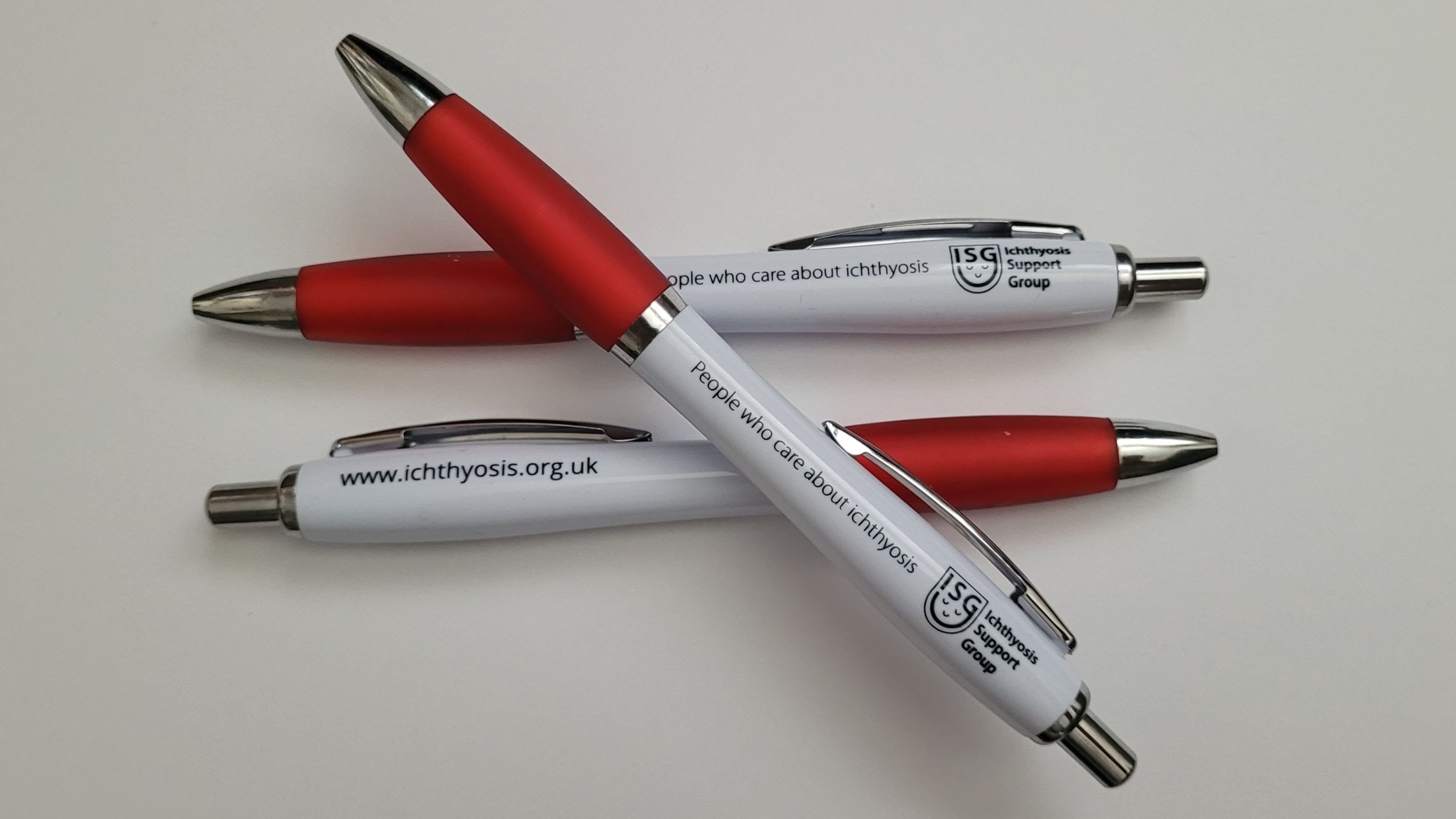 Two white and red ISG branded pens.